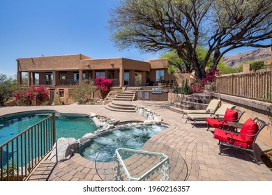 Swimming pool with hot tub and terraced patio at a luxury home in a desert environment. - Shutterstock ID 1960216357