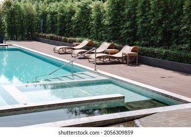 Swimming Pool Ladder and Sun Lounger in Poolside, Luxury Outdoor Swim Pool and Modern Decoration of Resort Hotel. Relaxation Swimming Pool in Summer Holiday and Leisure Vacation Lifestyles. - Powered by Shutterstock