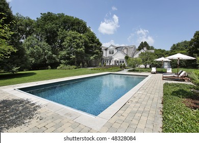 Swimming Pool Of Luxury Home With Deck Chairs