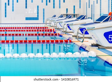 Swimming Pool With Marked Red And White Lanes. Empty Swimming Pool Without People With Quiet Standing Water. Water Sports In Indoor Pool.