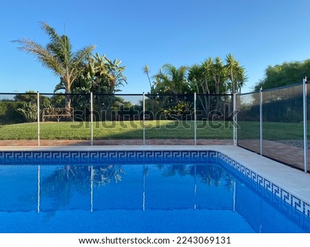 Swimming pool with mesh fencing in the garden of a private home