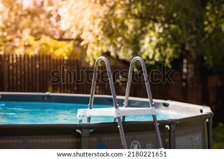 Swimming pool with metal frame for home and garden. Frame swimming pool in the yard. Solar banner.Installation of the pool. The concept of summer holidays and recreation.