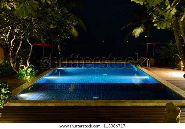The swimming pool\
at night without people.