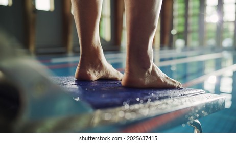 Swimming Pool: Professional Swimmer Standing On A Starting Block. Overcoming Fear, Determined Athlete Ready To Set New Record On A Championship. Stylish Cinematic Focus On Legs. Close-up Shot