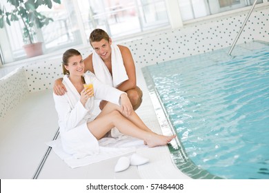 Swimming pool - young happy couple relax on poolside in luxury hotel