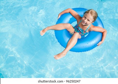 Swimming, summer vacation - lovely girl playing in blue water (space for text)