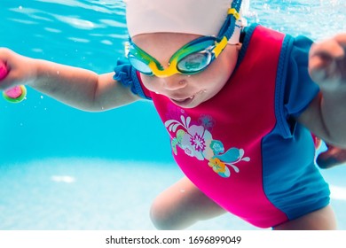 A Swimming Teacher Teaches A Kid To Swim In The Pool