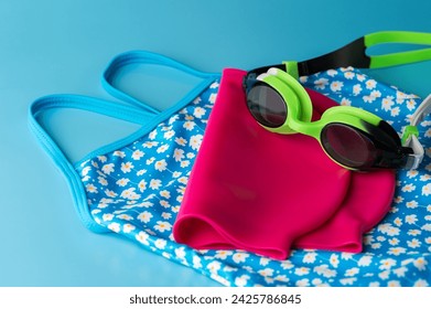 Swimming training theme. Bathing suit with goggles and red hat - Powered by Shutterstock