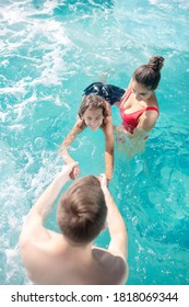 Swimming Training. Young Caring Dad And Mom In Swimming Suits Teaching Their Son To Swim, Everyone In Water