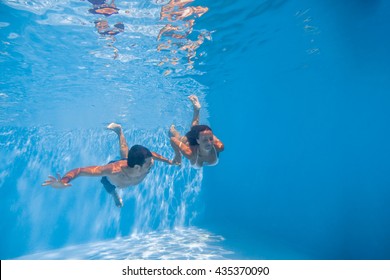 Swimming Underwater couple  in the swimming pool. - Powered by Shutterstock