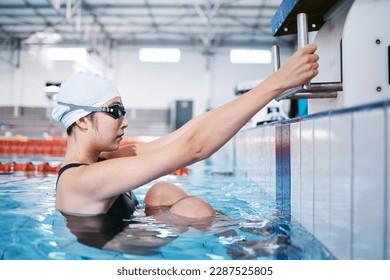 Swimming woman, ready for performance and sports with fitness, health and training for competition at indoor pool. Water sport, Asian athlete and exercise with focus and serious female swimmer - Powered by Shutterstock