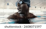 Swimming, workout and man in pool, water and practice for competition, healthy or routine in morning. Swimmer, athlete and black person with goggles for performance, exercise or preparation for sport