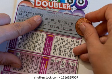 Swindon, England, UK - September 27th, 2019 - Hand Of Woman Holding Coin On Bingo Lottery Scratch Card For Cash Prizes To Be Won In British Pounds. Photographed In Swindon, England