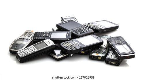 SWINDON, UK - APRIL 18, 2014: Pile Of Old Moblie Phones Ready For Recycling On A White Background