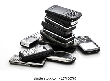 SWINDON, UK - APRIL 18, 2014: Pile of Old Moblie Phones ready for recycling on a white background