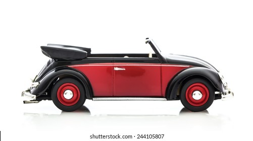 SWINDON, UK - DECEMBER 14, 2014: Convertible VW Beetle in Red and Black, Die cast model on a white background.