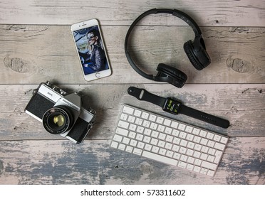 SWINDON, UK - FEBRUARY 7, 2017: Flat Lay With Old SLR Film Camera, IPhone, Apple Watch, Keyboard And Headphones