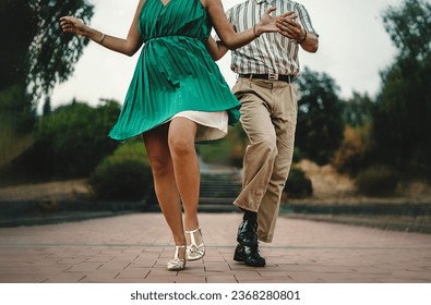 Swing Dance Steps in Motion - Close-up of dancers' feet and attire in swing dance outdoors. Distinctive vintage style details