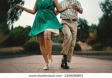 Swing Dance Steps in Motion - Close-up of dancers' feet and attire in swing dance outdoors. Distinctive vintage style details