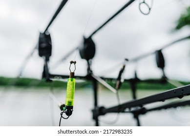 Swing fishing. Rods for carp fishing with signaling devices on holder. Rod pod. Fishing for pike, perch, carp on background of lake. Angler is fishing with carp technique.