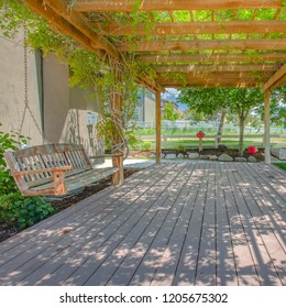 Swing Hanging On A Pergola Covering A Wooden Deck