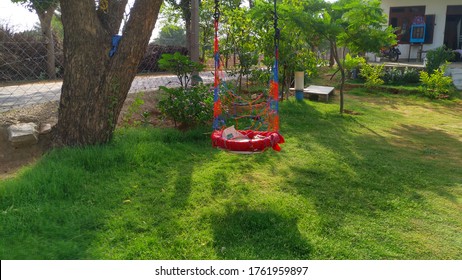 Swing Set. Image Of Childrens Swing Set In Green Park. Swing Is A Hanging Seat, Often Found At Playgrounds For Children.