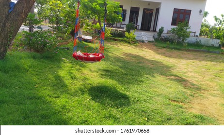 Swing Set. Image Of Childrens Swing Set In Green Park. Swing Is A Hanging Seat, Often Found At Playgrounds For Children.