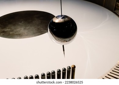 Swinging ball of the Eddy pendulum in a science demonstration. - Powered by Shutterstock