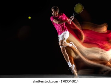 Swinging volley. Young caucasian man, male tennis player in white pink sportwear playing tennis in mixed light on dark background. Concept of motion, power, speed, healthy lifestyle, professional - Powered by Shutterstock