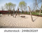 Swings on a sand-covered playground. Entertainment complex for children