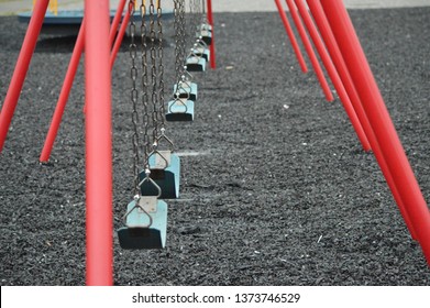 Swings On A Tire Mulch School Playground  On A Cloudy Day