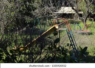 Swings Slides And Merry Go Round In Abandoned Overgrown Childrens Playground.