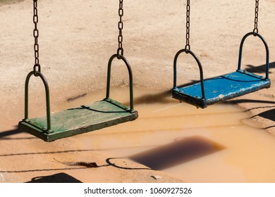 Swingset Over A Puddle On A Playground