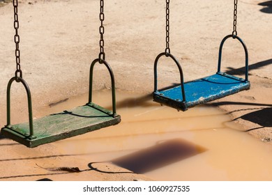 Swingset Over A Puddle On A Playground