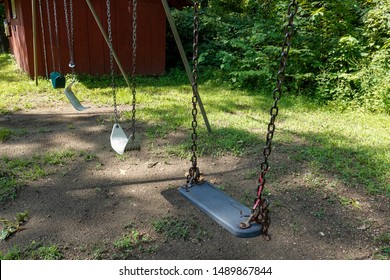 Swingset At Summer Camp With A Broken Swing Symbolizing A Loss Of Innocence.