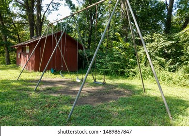 Swingset At Summer Camp With A Broken Swing Symbolizing A Loss Of Innocence.