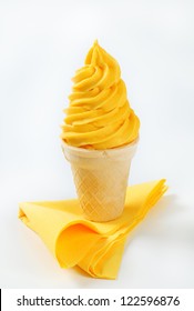 Swirl Of Yellow Soft Serve Ice Cream In A Cone
