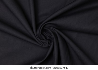 Swirled black color fabric texture background. This fabric is made from polyester.
