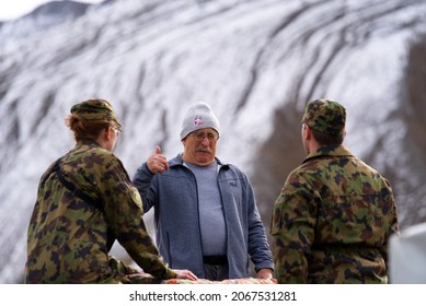 Swiss Army Soldiers Talking With Elderly Man At Air Show Of Swiss Air Force At Axalp On A Cloudy Autumn Day. Photo Taken October 19th, 2021, Brienz, Switzerland.