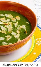 Swiss Chard And Potato Cream Soup With Chopped Roasted Almonds In Brown Ceramic Bowl