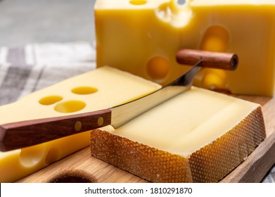 Swiss Cheeses, Block Of Medium-hard Yellow Cheese Emmental Or Emmentaler With Round Holes And Matured Gruyere Close Up