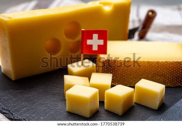 Swiss\
cheeses, block of medium-hard yellow cheese emmental or emmentaler\
with round holes and matured gruyere close\
up