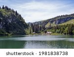 Swiss countryside. View of the lake in the swiss alps surrounded with pines and rocky mountains in summer. Lac des Chavonnes, Canton Vaud, Switzerland