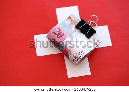 Swiss franc banknotes and flag. The current francs money bills lies on flag in big amount. The concept of business in Switzerland