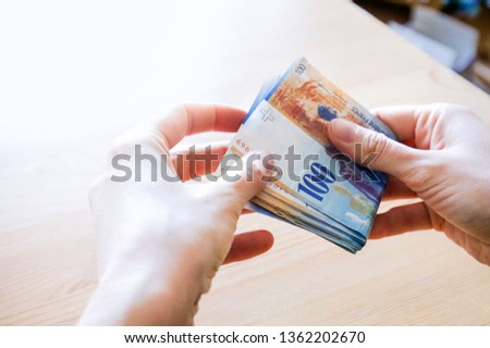 Swiss francs. Currency of Switzerland. Hands giving money. Foto stock © 