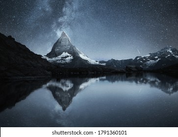 Swiss landscape. Matterhorn and reflection on the water surface at the night time. Milky way above Matterhorn, Switzerland. Travel image. 