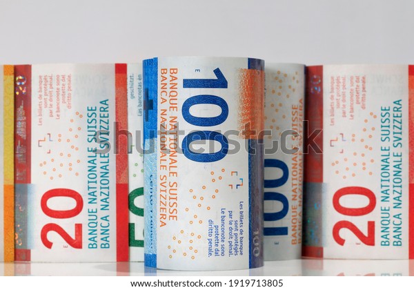 Swiss money. Swiss franc banknotes\
have been rolled up and placed side by side. CHF\
currency.\
