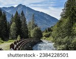 Swiss mountains range with fast flowing river.