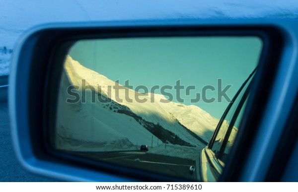 Swiss mountains\
reflecting from side\
mirror