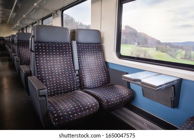 Swiss Train Interior With Comfortable Chairs, On Two Rows, A Table And Nature View On Window. Public Transport Context. Passenger Train Interior.